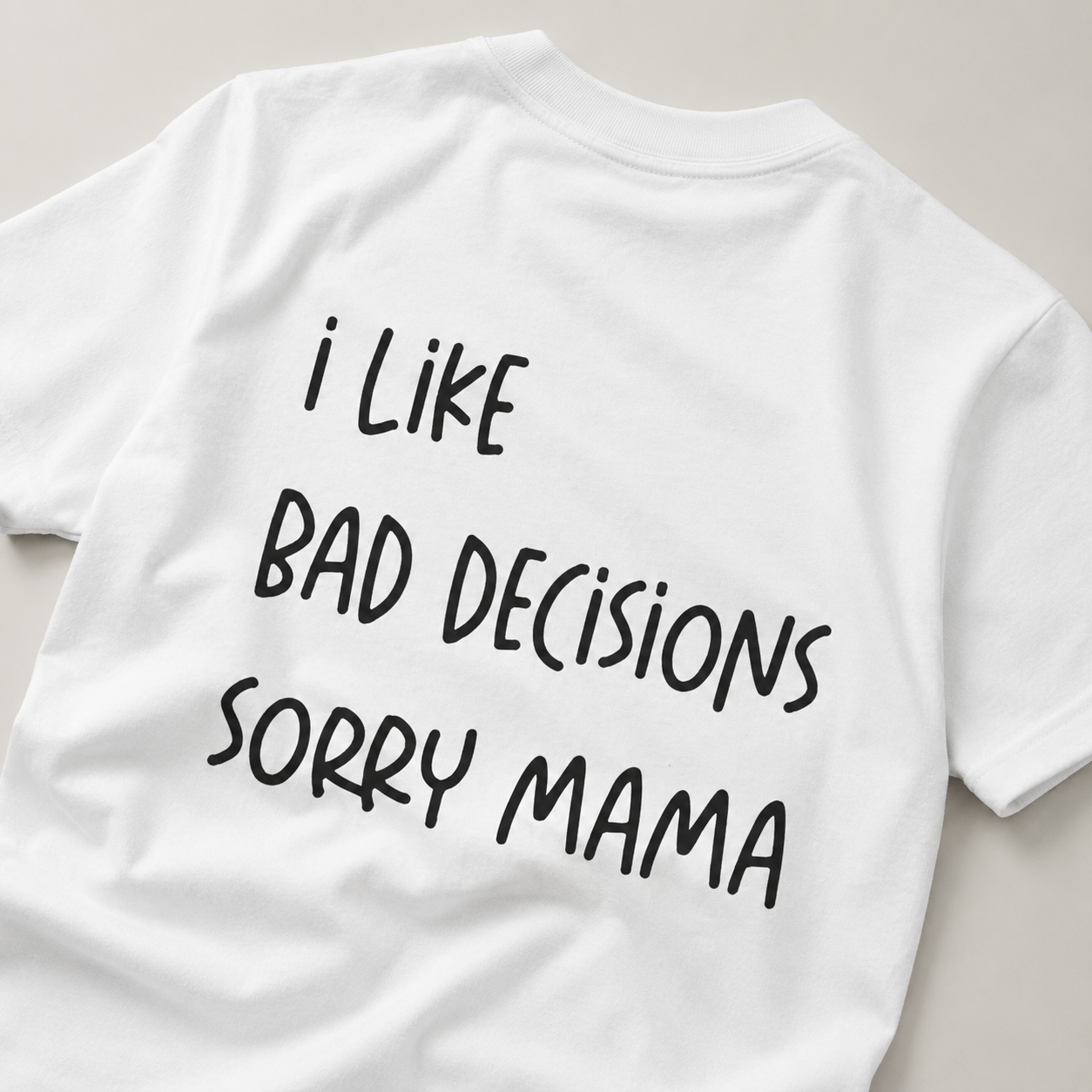 White t-shirt with black text 'I Like Bad Decisions Sorry Mama' on a light gray background