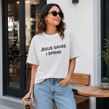 Woman wearing a white t-shirt with 'JESUS SAVES I SPEND' text, standing outside a building.
