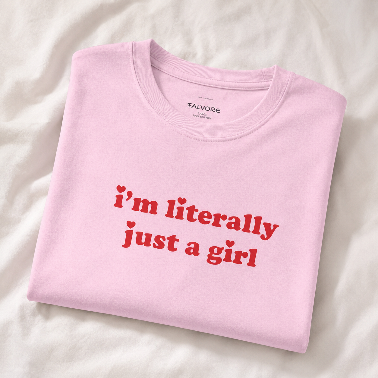 Folded pink t-shirt with red text on a white background