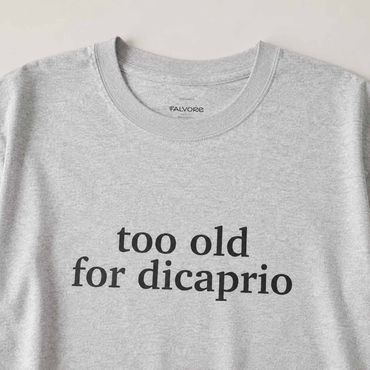 Gray t-shirt with 'too old for dicaprio' text on a light gray background